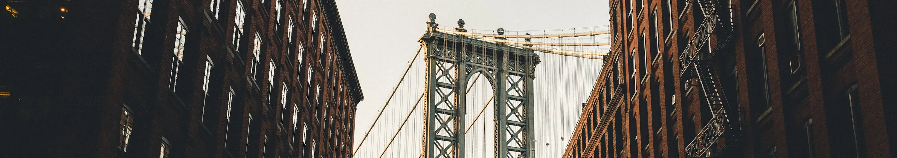 A ground-level view of a bridge, showcasing its structure and height against the sky.